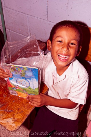 A little boy smiling at the school supplies we gave him - Utila, Honduras