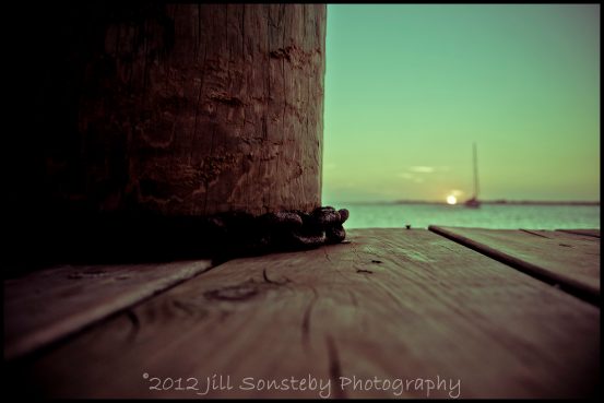 A sunset in the background of a chain on a dock in Utila, Honduras