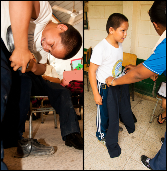 A boy is helping his little brother try on shoes and the next day he received a new uniform too!