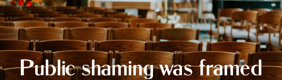 Empty church sanctuary with rows of wooden pews and soft natural light.